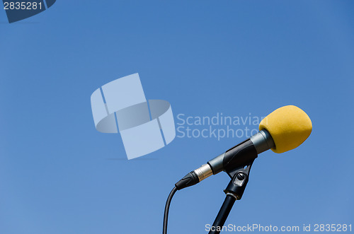 Image of yellow microphone blue sky bakcground 