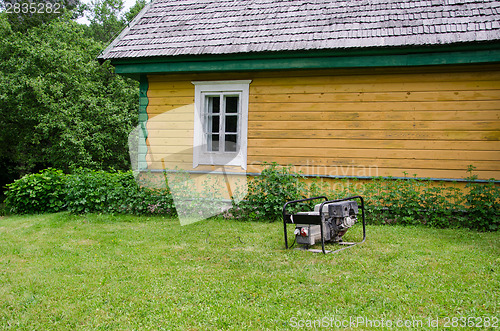 Image of diesel electricity generator work near rural house 
