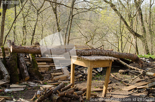 Image of board logs piles and wooden table for cutting log  