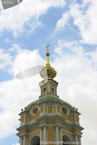 Image of russian bell tower with clock on blue sky background