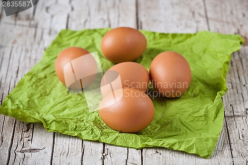 Image of  fresh brown eggs on green napkin