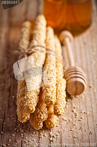 Image of bread sticks grissini with sesame seeds and honey