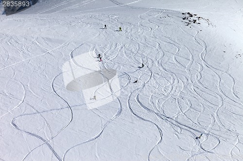 Image of Snowboarders and skiers on off-piste slope at sun day