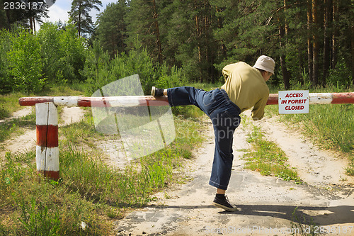 Image of Man overcomes barrier in fire-dangerous period, ignoring ban