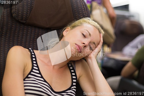 Image of Lady traveling napping on a train.