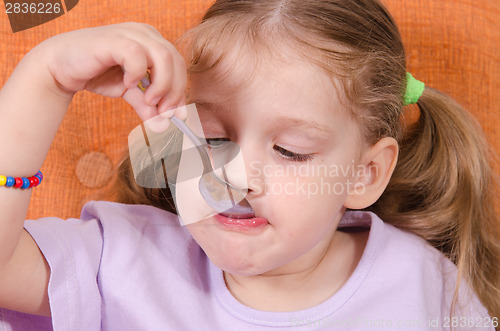 Image of Funny baby eats with a spoon