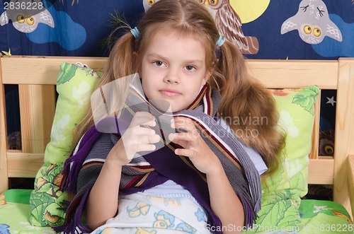 Image of Diseased girl with scarf lying in her bed