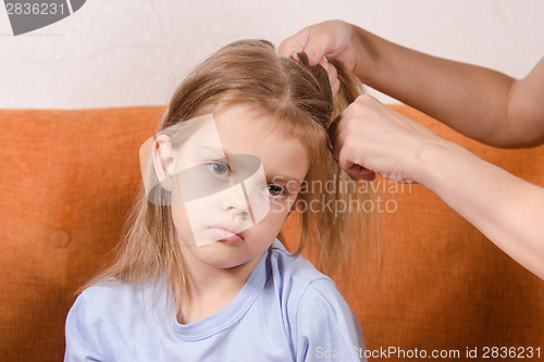 Image of Mom braids hair sad girl