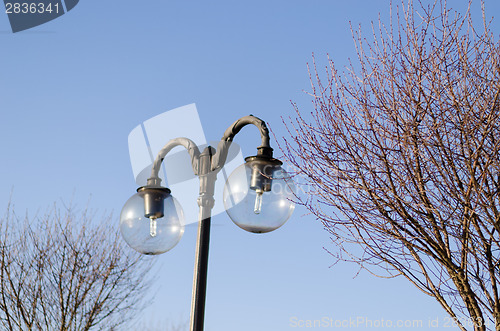 Image of glass street lamp on blue sky background 