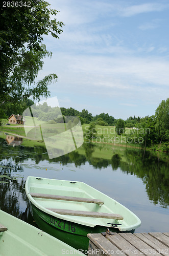 Image of boat moored to wooden footbridge at lake shore 