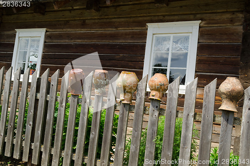 Image of rural fence with old cracked earthen jars outdoor 