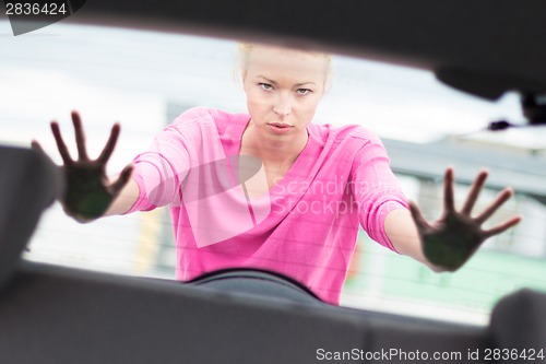 Image of Woman pushing a car.