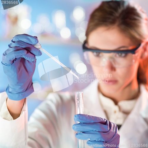 Image of Attractive young scientist pipetting.