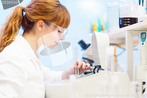 Image of Attractive young scientist pipetting.