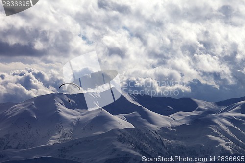 Image of Evening sunlight mountain with clouds and silhouette of paraglid