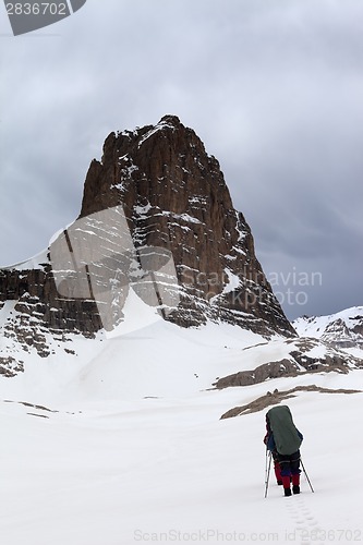 Image of Two hikers at snowy storm mountains