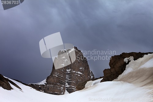 Image of Snowy rocks and storm clouds