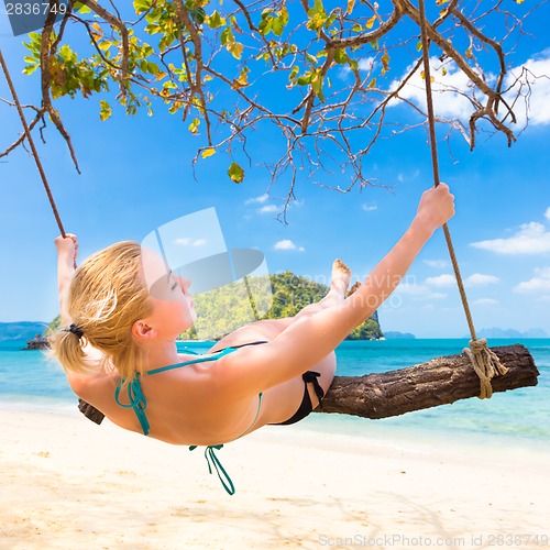 Image of Lady swinging on the tropical beach