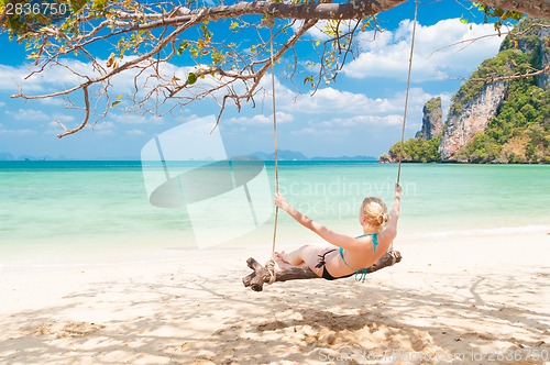 Image of Lady swinging on the tropical beach