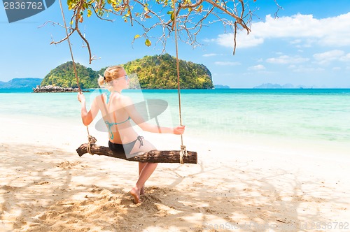 Image of Lady swinging on the tropical beach