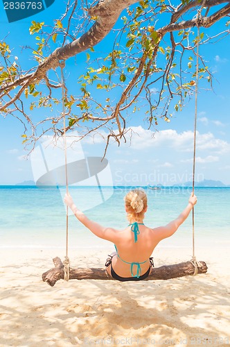 Image of Lady swinging on the tropical beach
