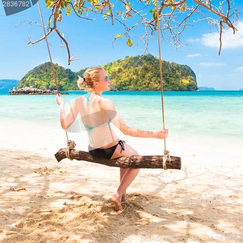 Image of Lady swinging on the tropical beach