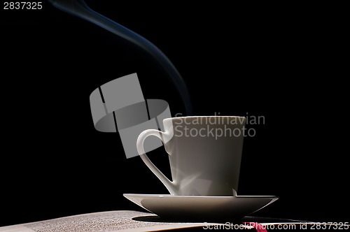 Image of Coffee cup with coffee beans with old book