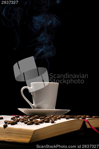 Image of Coffee cup with coffee beans with old book