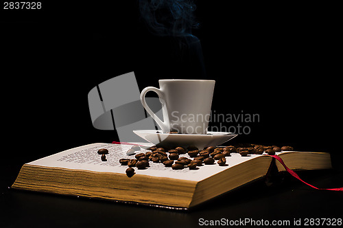 Image of Coffee cup with coffee beans with old book