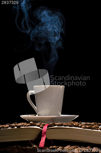 Image of Coffee cup with coffee beans with old book