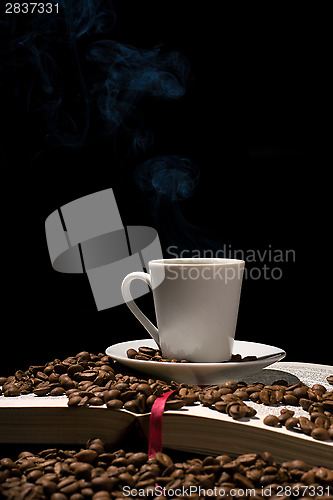 Image of Coffee cup with coffee beans with old book