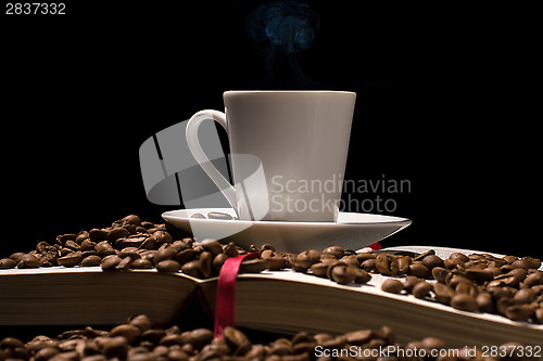 Image of Coffee cup with coffee beans with old book