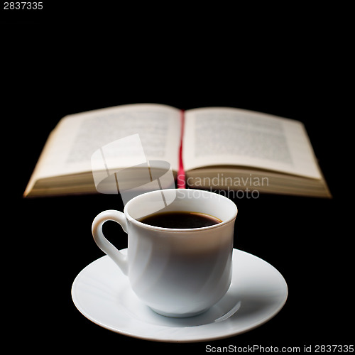 Image of Coffee cup with coffee beans with old book