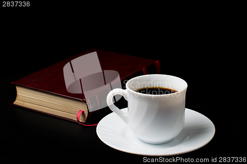 Image of Coffee cup with coffee beans with old book