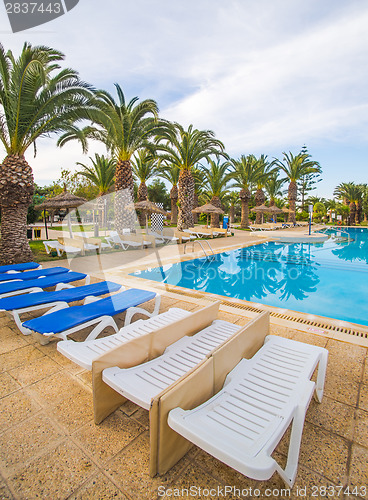 Image of swimming pool and deck chairs at luxury resort