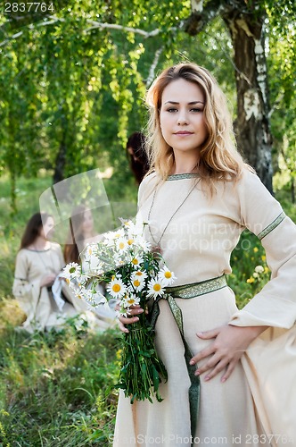 Image of Pretty woman with bouquet of camomiles
