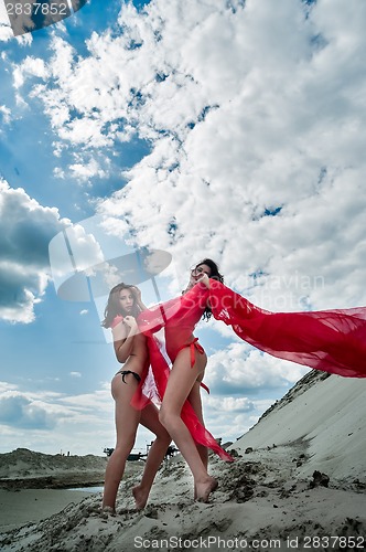 Image of Sexy topless girls relax on sand