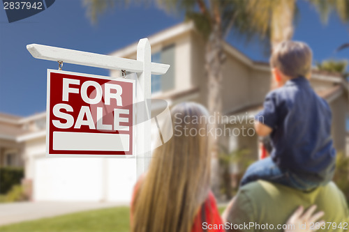 Image of Family Facing For Sale Real Estate Sign and House