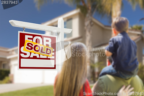 Image of Family Facing Sold For Sale Real Estate Sign and House
