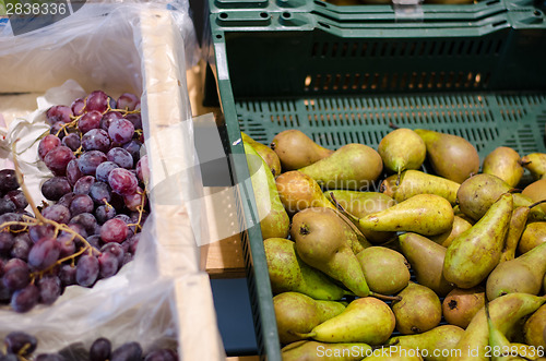 Image of green pear and grapes bunch in plastic box store 