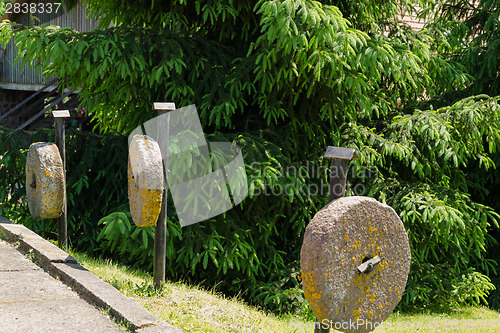 Image of three pillars ancient millstones along hang trees 