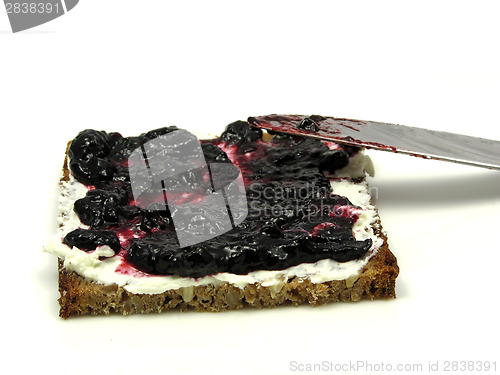 Image of Wholemeal butterbread  with bilberry jam placed on a round plate