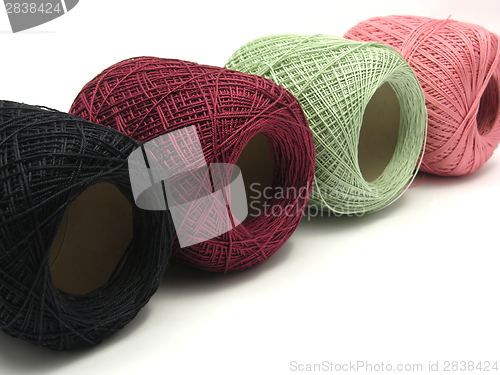 Image of Four balls of wool  lying in line on a white background