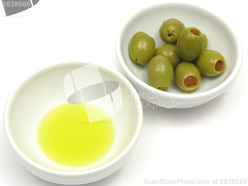 Image of Two bowls of chinaware with olive oil and olives on white background