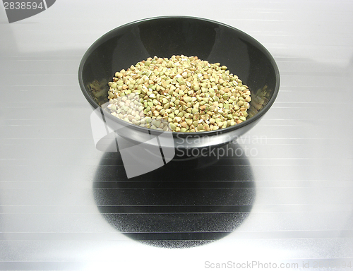 Image of Black bowl of chinaware with buckwheat on reflecting surface