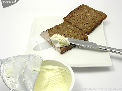 Image of Wholemeal bread with cream cheese on a plate with knife