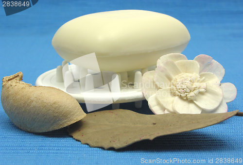 Image of Beige soap with decoration articles on a light blue background