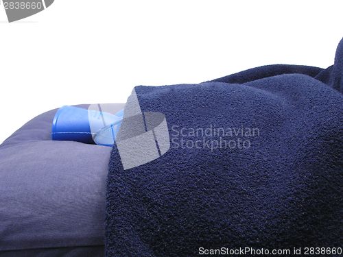 Image of Blue hot-water bag wrapped in a blue blanket on a blue pillow