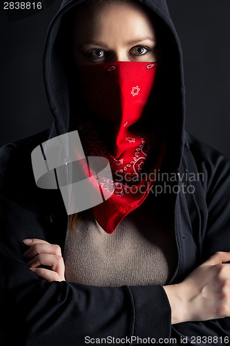 Image of girl in black hood with a red shawl on his face