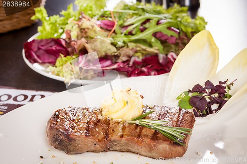 Image of Grilled beef steak topped with butter and rosemary